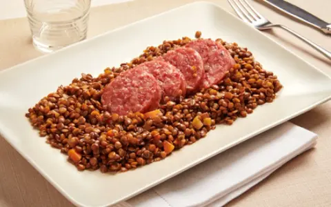 Piatto di lenticchie con fette di cotechino, un classico della tradizione.