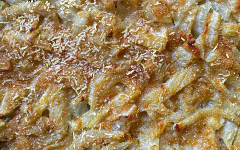 Finoçchi gratinati al forno con besciamella, dorati e croccanti, con formaggio filante e una spolverata di parmigiano.
