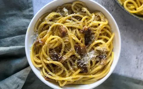 Un piatto di spaghetti alla carbonara, cremosi e saporiti, perfetti per una ricetta carbonara per 2. Guarniti con guanciale croccante e pecorino grattugiato.
