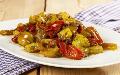 Un piatto invitante di verdure miste cotte, un'ottima gurguglione ricetta, con peperoni, zucchine e pomodori conditi con erbe aromatiche.