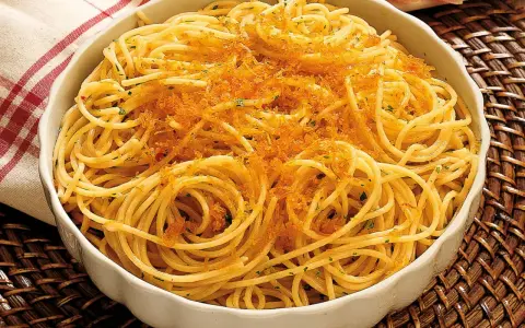 Spaghetti alla bottarga, un piatto saporito con pasta dorata e una generosa spolverata di uova di pesce essiccate.