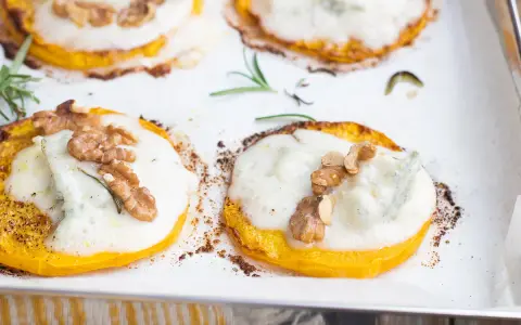 Fette di zucca al forno con gorgonzola fuso, noci croccanti e rosmarino. Un connubio di sapori autunnali.