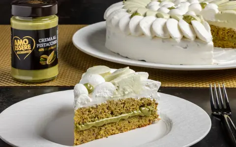 Una fetta di torta soffice al pistacchio, con crema al pistacchio e panna montata. Accanto, un barattolo di crema al pistacchio.