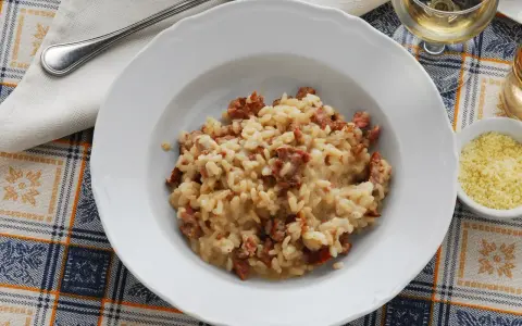 Un piatto di risotto alla pilota cremoso, con pezzetti di salsiccia, pronto per essere gustato.