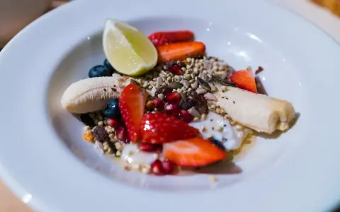 Yogurt con frutta secca, fragole, mirtilli, banana e lime. Un mix colorato e salutare per iniziare la giornata.