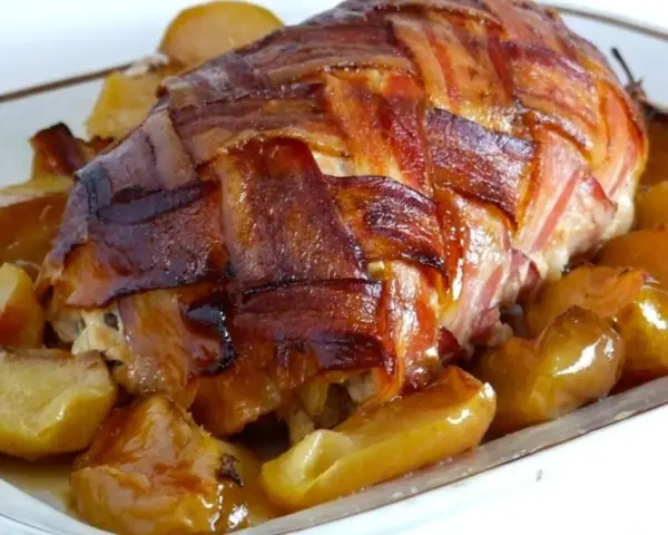 Arista di maiale alla birra, un piatto fatto in casa da Benedetta, avvolta in pancetta croccante e servita con patate dorate.
