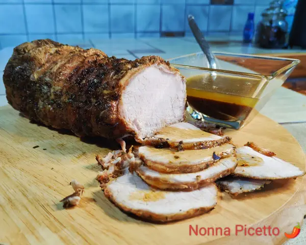 Arista arrosto succulenta, affettata su tagliere, con sughetto. La differenza tra lonza e arista è nella posizione del taglio.