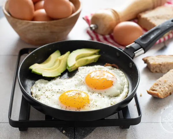 Due uova alla griglia con avocado e pane tostato, un inizio perfetto per la giornata.