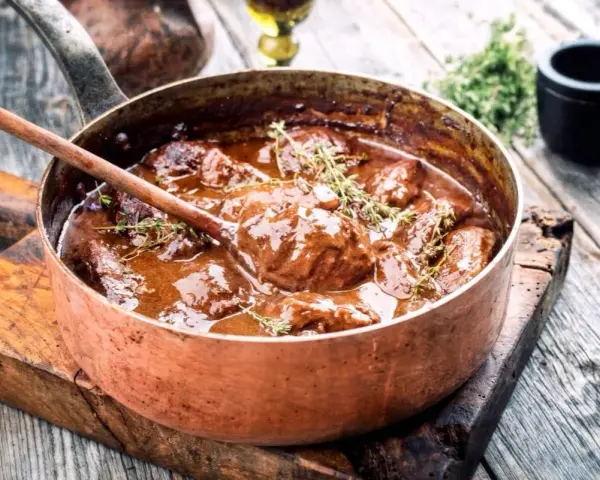 Succulento brasato ricetta semplice in una pentola di rame, pronto per essere servito.
