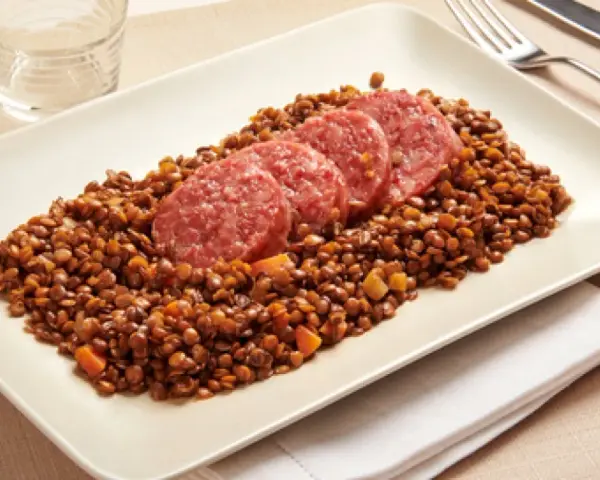 Piatto di lenticchie con fette di cotechino, un classico della tradizione.