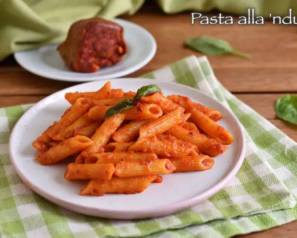 Penne al sugo piccante di nduja, guarnite con basilico fresco. Un piatto che scalda il cuore e il palato.