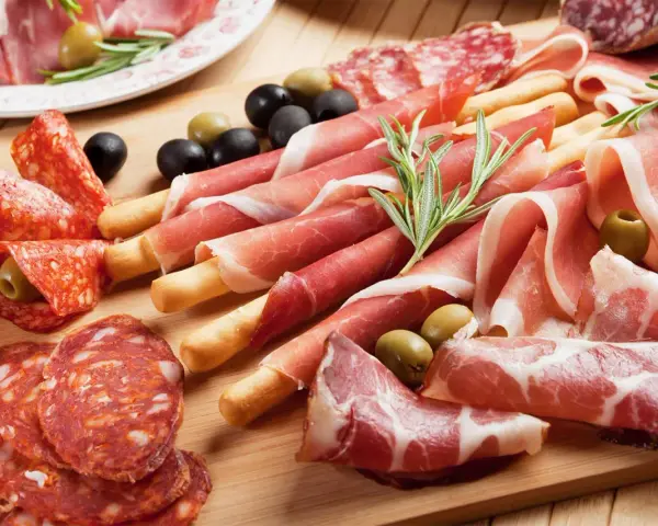 Tagliere con salumi misti, tra cui affettati non di maiale, olive e rosmarino.