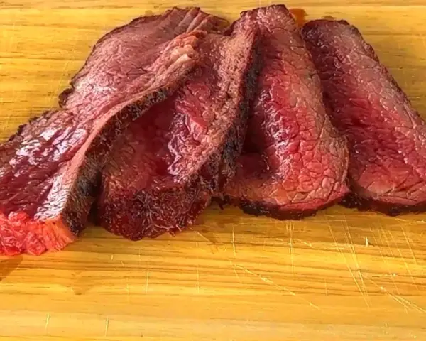 Fette succulente di spinacino di manzo, cotte alla perfezione, adagiate su un tagliere di legno.