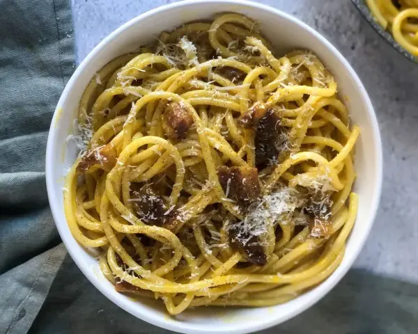 Un piatto di spaghetti alla carbonara, cremosi e saporiti, perfetti per una ricetta carbonara per 2. Guarniti con guanciale croccante e pecorino grattugiato.