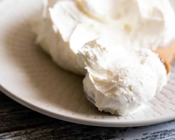 Crema bianca e soffice su un piatto, pronta per essere usata come ingredienti per mascarpone.