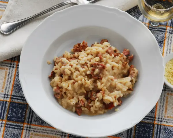 Un piatto di risotto alla pilota cremoso, con pezzetti di salsiccia, pronto per essere gustato.