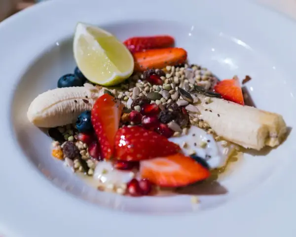Yogurt con frutta secca, fragole, mirtilli, banana e lime. Un mix colorato e salutare per iniziare la giornata.