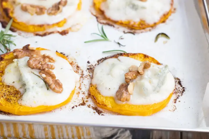 Fette di zucca al forno con gorgonzola fuso, noci croccanti e rosmarino. Un connubio di sapori autunnali.