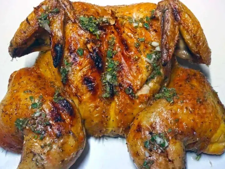 Un succulento pollo alla brace, dorato e profumato, condito con erbe aromatiche e aglio.
