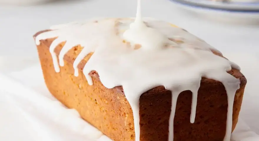 Dolce loaf ricoperto da una glassa lucida, preparata con zucchero a velo e acqua, che cola sui lati.