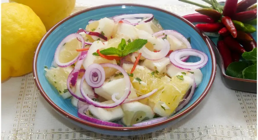 Fresca insalata di limoni, pompelmo, cipolla rossa e peperoncino, guarnita con menta.