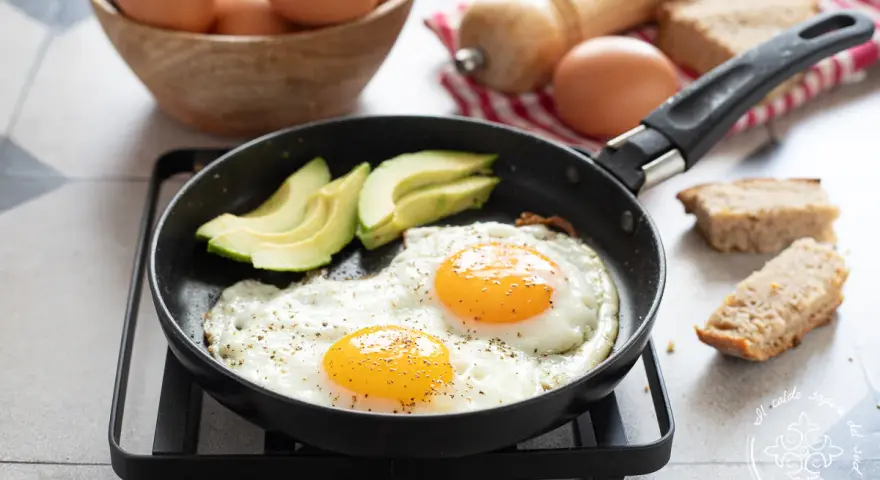 Due uova alla griglia con avocado e pane tostato, un inizio perfetto per la giornata.