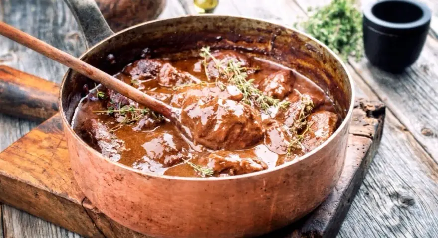 Succulento brasato ricetta semplice in una pentola di rame, pronto per essere servito.