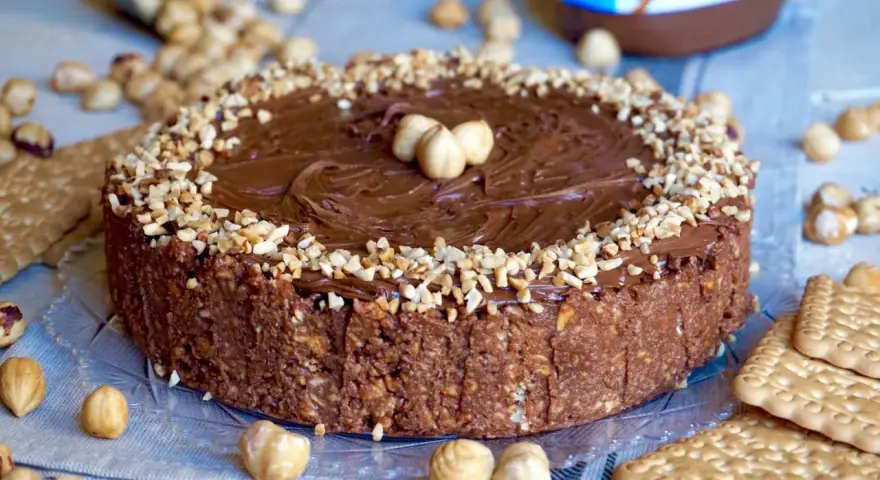 Torta Nutella 3 ingredienti: golosa e facile, con croccante base di biscotti e nocciole, ricoperta di crema alla nocciola e granella.
