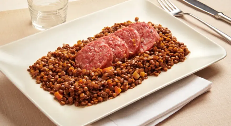 Piatto di lenticchie con fette di cotechino, un classico della tradizione.