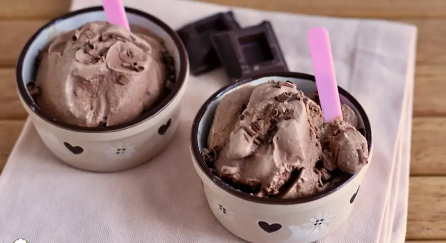 Due coppette di cremoso gelato al cioccolato, guarnito con scaglie, pronto da gustare. Un delizioso gelato cioccolato senza gelatiera.