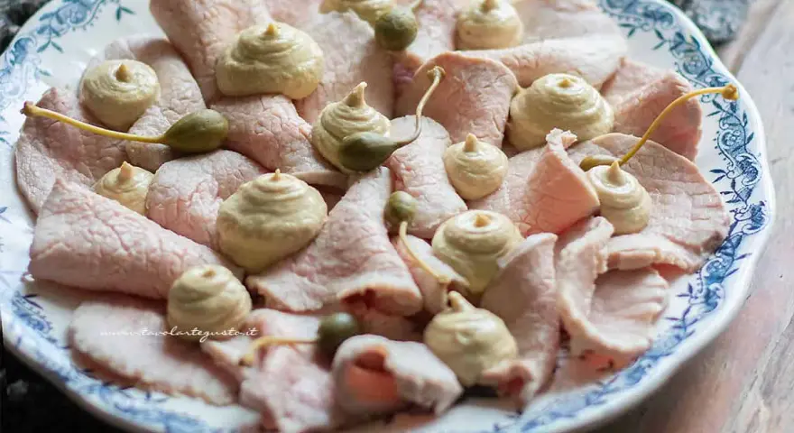 Vitello tonnato ricetta originale piemontese: fettine sottili di vitello rosa, guarnite con salsa tonnata e capperi.