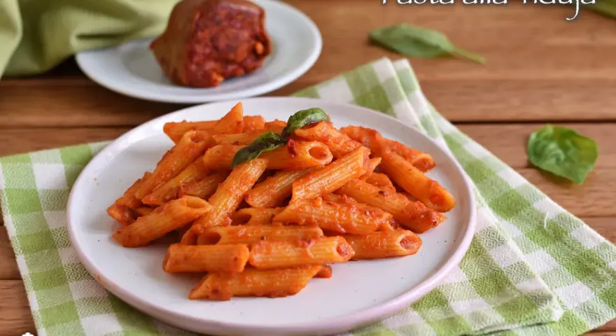 Penne al sugo piccante di nduja, guarnite con basilico fresco. Un piatto che scalda il cuore e il palato.