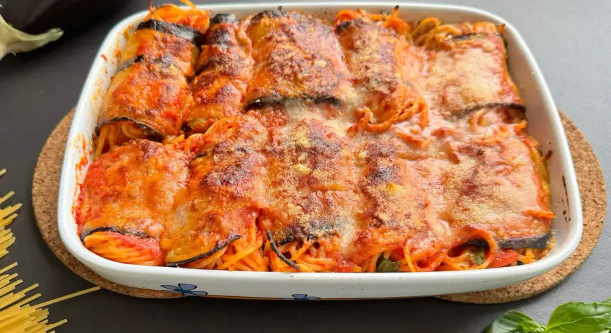Involtini di melanzane ripieni di spaghetti al sugo, gratinati al forno con formaggio fuso.