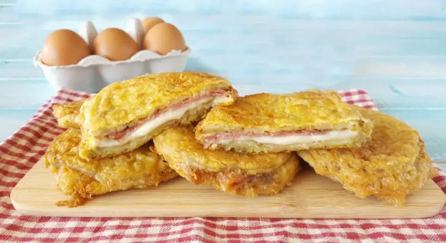 Fette dorate di melanzane alla pullastiello, ripiene di formaggio filante e salumi, pronte per essere gustate.