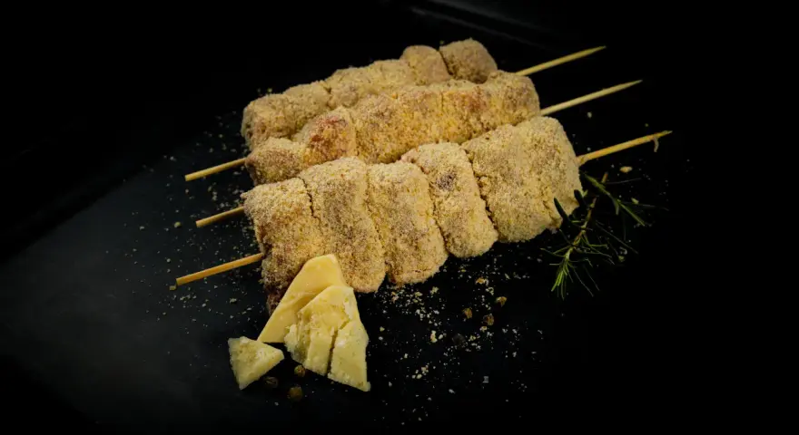 Bombette pugliesi alla brace, impanate e pronte per la cottura, con formaggio e rosmarino.