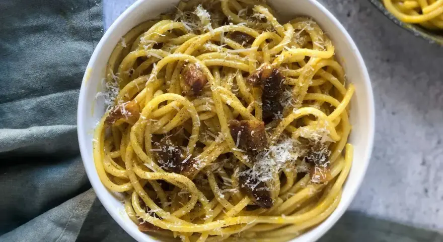 Un piatto di spaghetti alla carbonara, cremosi e saporiti, perfetti per una ricetta carbonara per 2. Guarniti con guanciale croccante e pecorino grattugiato.