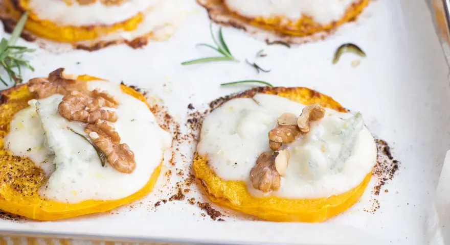 Fette di zucca al forno con gorgonzola fuso, noci croccanti e rosmarino. Un connubio di sapori autunnali.