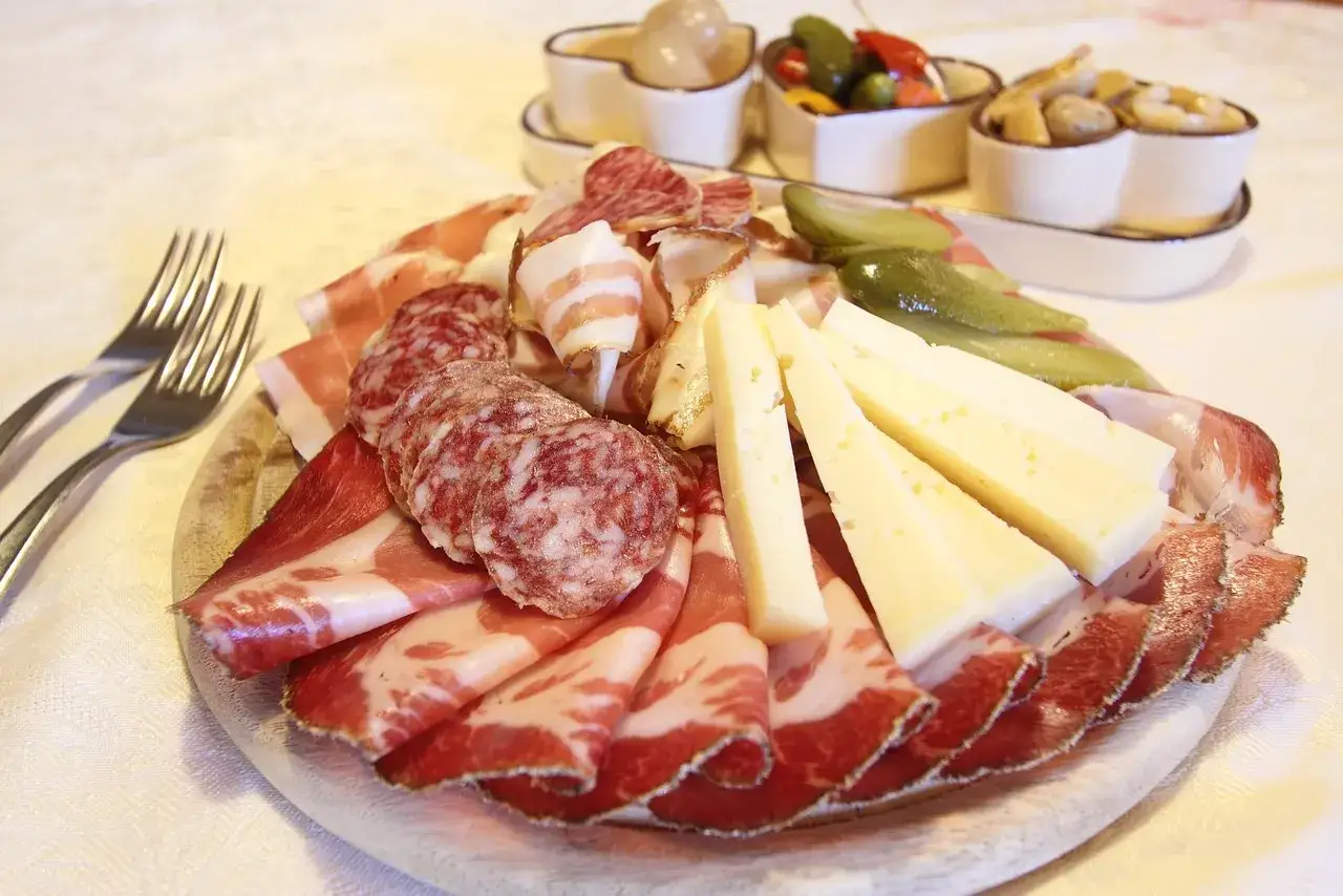 Un tagliere ricco di salumi misti, formaggio e sottaceti, pronto per essere gustato.