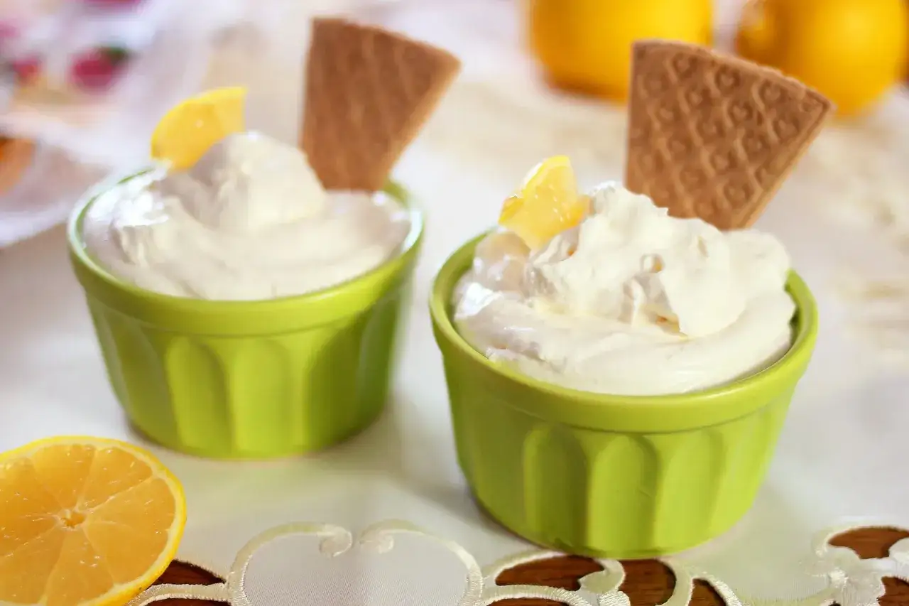 Due coppette di crema al mascarpone con limone e cialda, perfetti ingredienti per un dolce fresco.