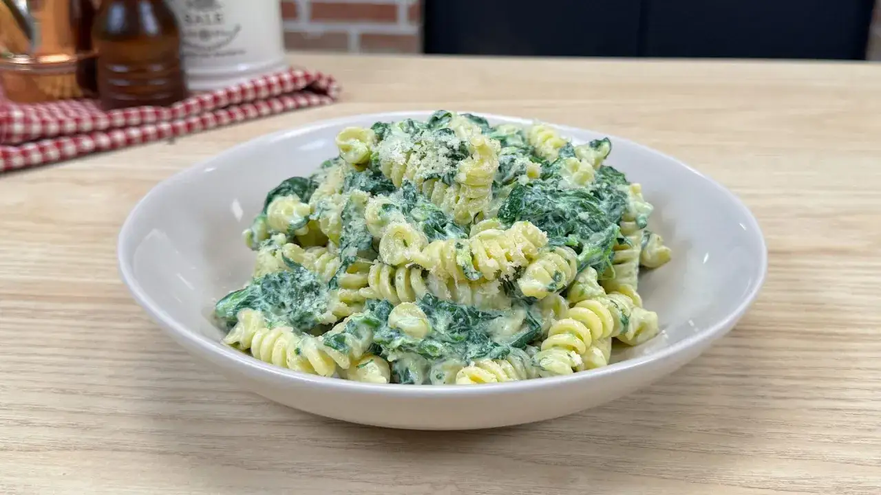 Fusilli cremosi con spinaci e parmigiano, un piatto semplice e gustoso.