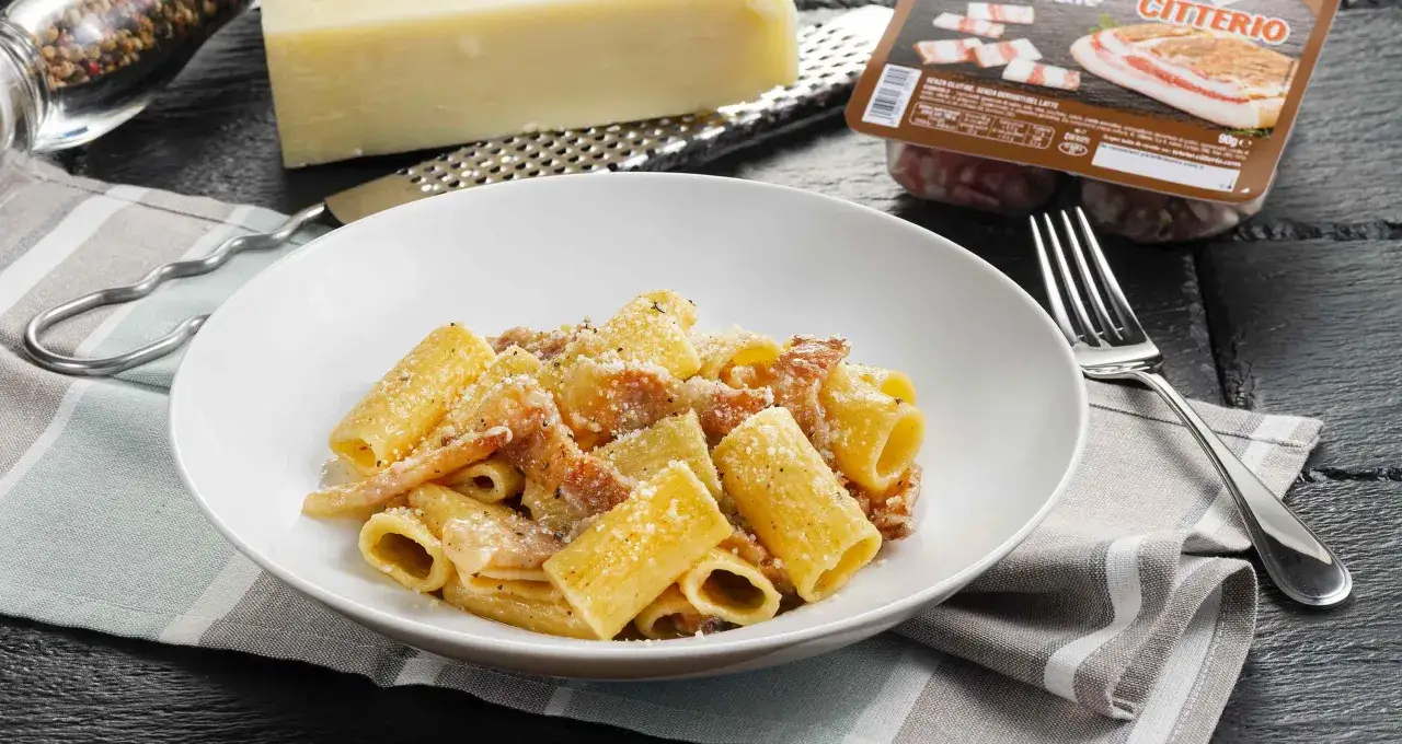 Piatto di pasta alla gricia fumante, con guanciale croccante e pecorino grattugiato. Ingredienti freschi e sapore autentico.