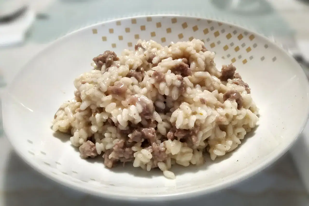 Risotto cremoso con salsiccia sbriciolata, un piatto gustoso dove i tastasal ingredienti si fondono perfettamente.