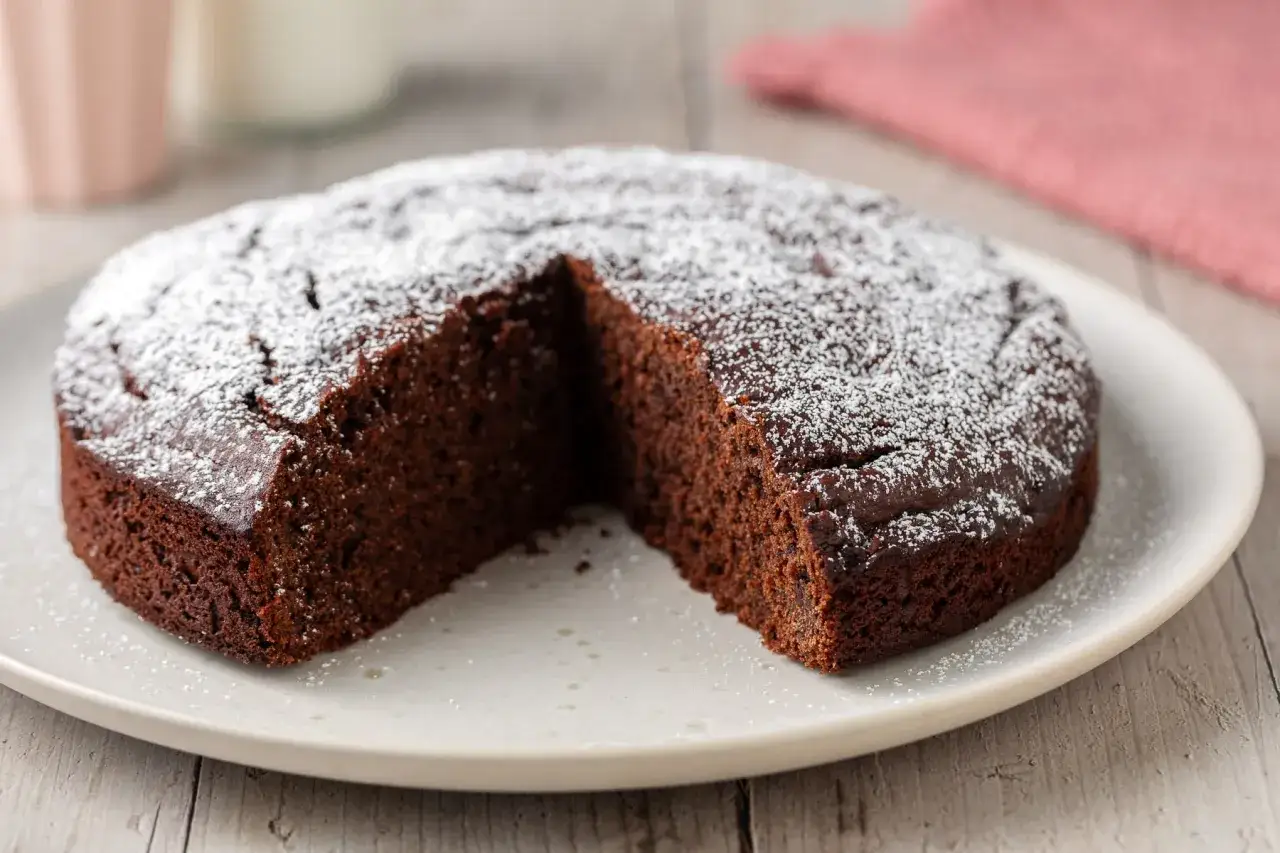 Una deliziosa torta fondente al cioccolato, cosparsa di zucchero a velo, attende di essere gustata.