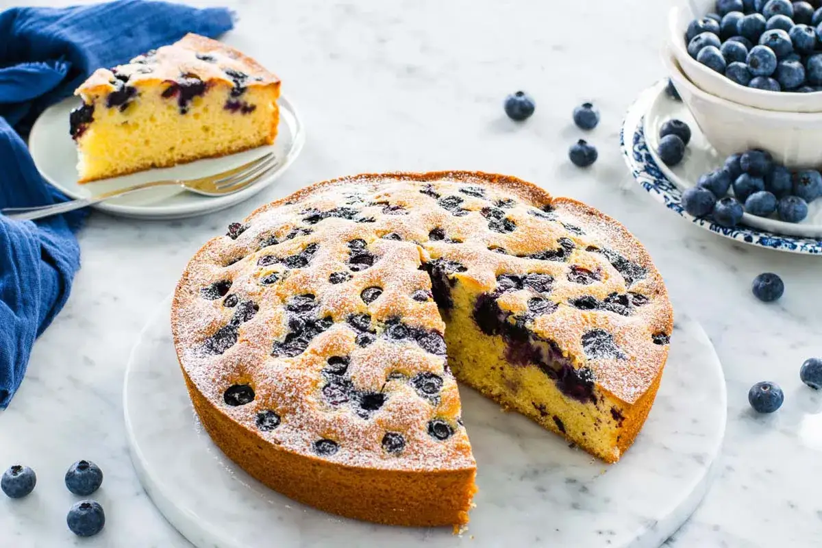 Torta 7 vasetti con mirtilli, soffice e profumata, una delle tante varianti golose. Una fetta è già servita.