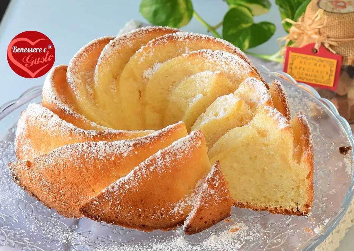 Un soffice ciambellone allo yogurt greco, spolverato di zucchero a velo, pronto per essere gustato.