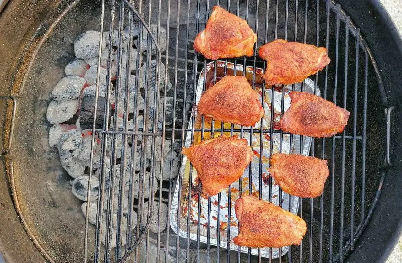 Sette succulenti pezzi di pollo alla brace, conditi e pronti per essere gustati, cuociono sulla griglia sopra le braci ardenti.