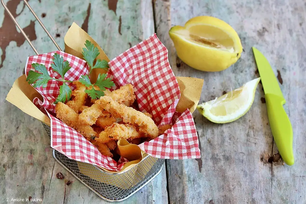 Croccante trippa fritta in cestino con tovaglietta a quadri rossi, limone e prezzemolo.