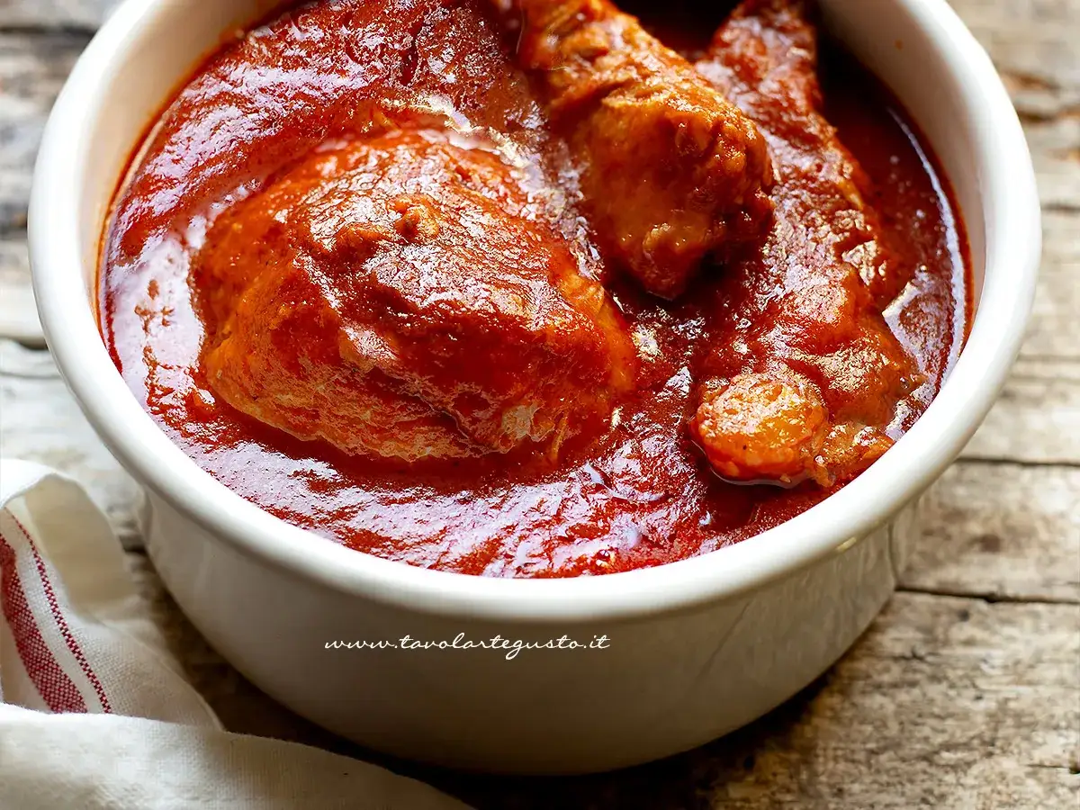 Pezzi di pollo succulenti immersi in un ricco sugo rosso, un assaggio della genovese napoletana.