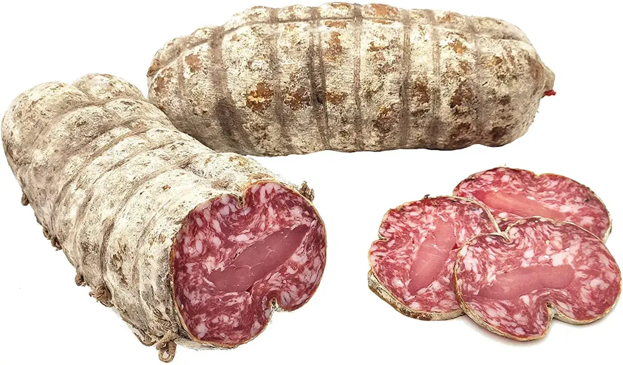 Due salami interi e tre fette mostrano la differenza tra salame e sopressa: la carne macinata e il grasso visibile.
