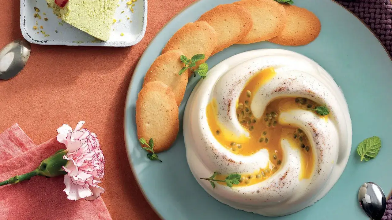 Delizioso dolce bianco con cuore di frutto della passione, biscotti e una fetta di torta verde.